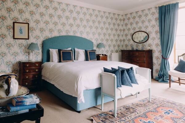 The blue bedroom with patterned wallpaper at The Salwey Lodge near Ludlow