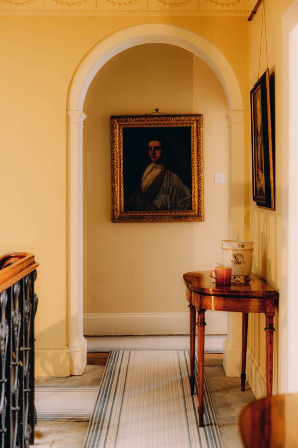 A family portrait through an archway on the landing at The Salwey Lodge near Ludlow