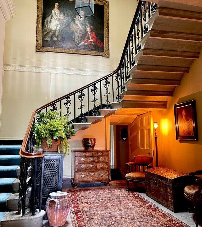 The main staircase and hall in warm lamplight at The Salwey Lodge near Ludlow